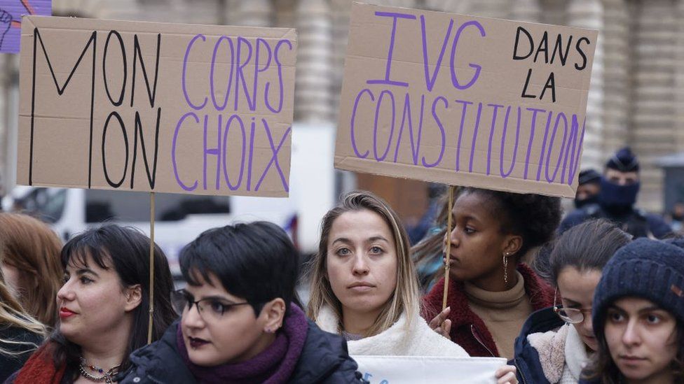 Placards reading "My body my choice" (L) and "Abortion in the Constitution" are seen during a rally to call for the constitutionalisation of the right to abortion outside the Senate in Paris, on February 01, 2023.