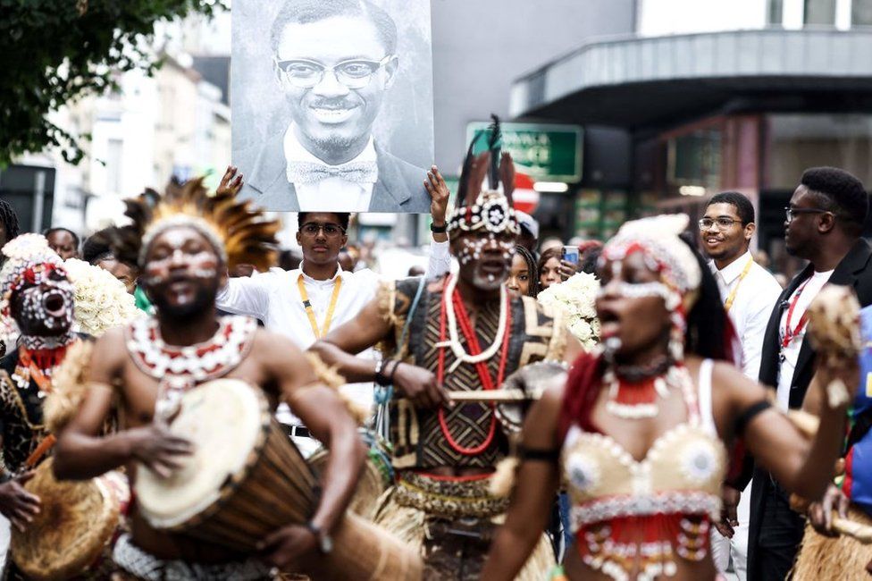 People take part a march to pay tribute to Patrice Lumumba (portrait) before the departure of his last remains to DR Congo in Brussels on 21 June 2022.
