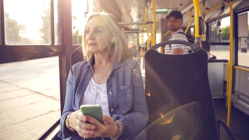 Older woman and young man on a bus (stock photo)