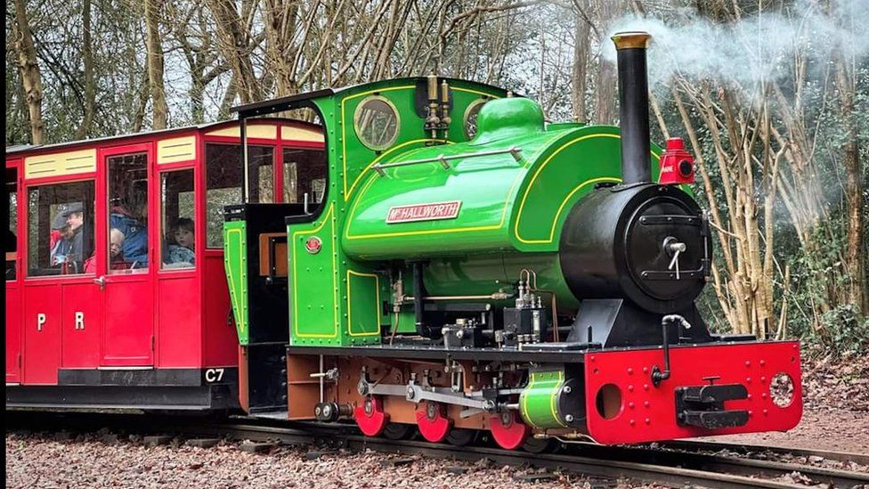 Perrygrove Steam Railway in Gloucestershire with a green engine pulling its carriages