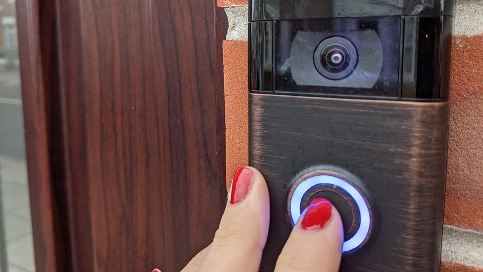 finger pushing doorbell