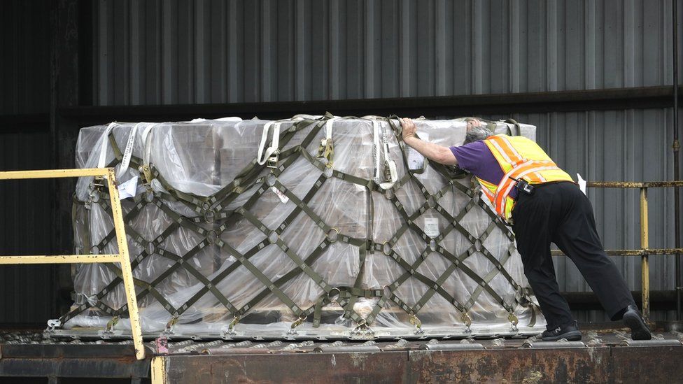 Pallets of baby formula are unloaded from a FedEx cargo plane upon arrival at Dulles International Airport on May 25, 2022