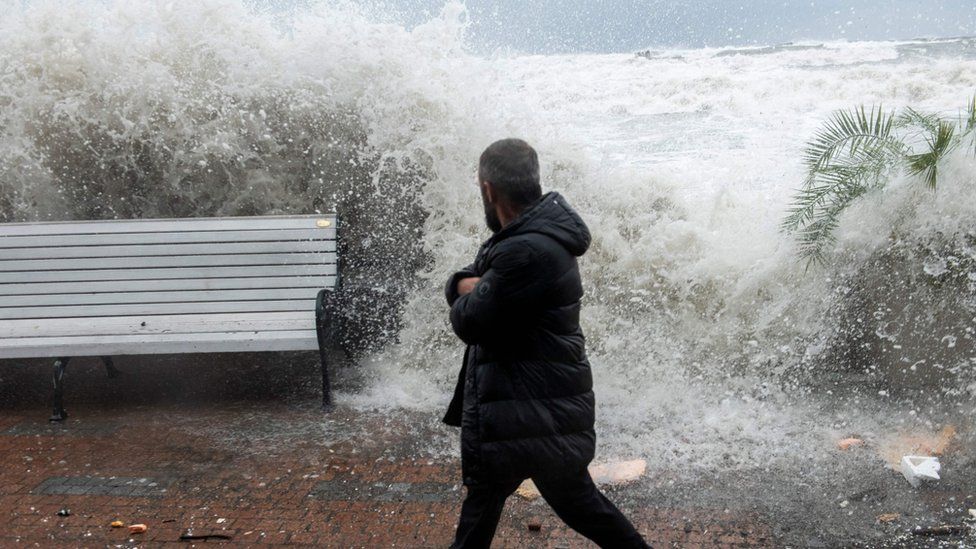 A man walks as big waves crash against Sochi's seafront, southern Russia. Photo: 27 November 2023