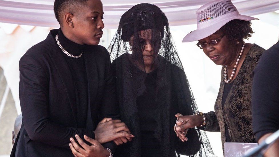 Grace Mugabe (C), the widow of former Zimbabwe President Robert Mugabe, is escorted by her son Bellermine Chatunga Mugabe (L) as she arrives to attend the official farewell ceremony for her later husband on September 14, 2019 held for family and heads of state at the National Sports Stadium in Harare