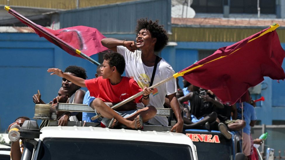 Supporters on a truck wave flags and chant for their political candidate in Honiara on 15 April