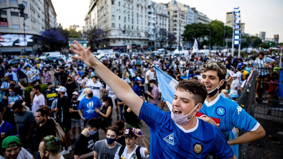 Fans cheer for Diego Maradona after the news of his death