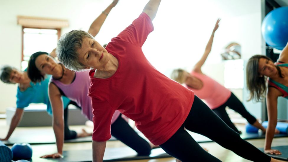 Older women doing yoga stretches