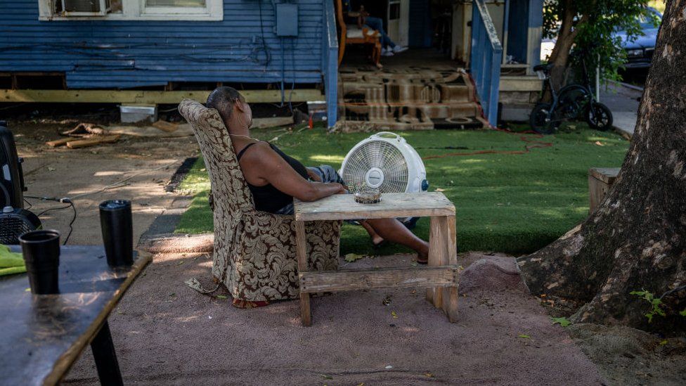 Yvette Johnson, 54, sits next to a fan outside of her families home on June 10, 2022 in Houston, Texas