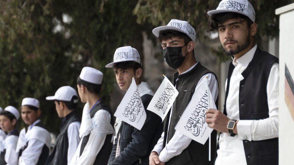 Afghan school boys holding Taliban flags align during a ceremony held to mark the start of the new academic year at Amani High School in Kabul on March 20, 2024.