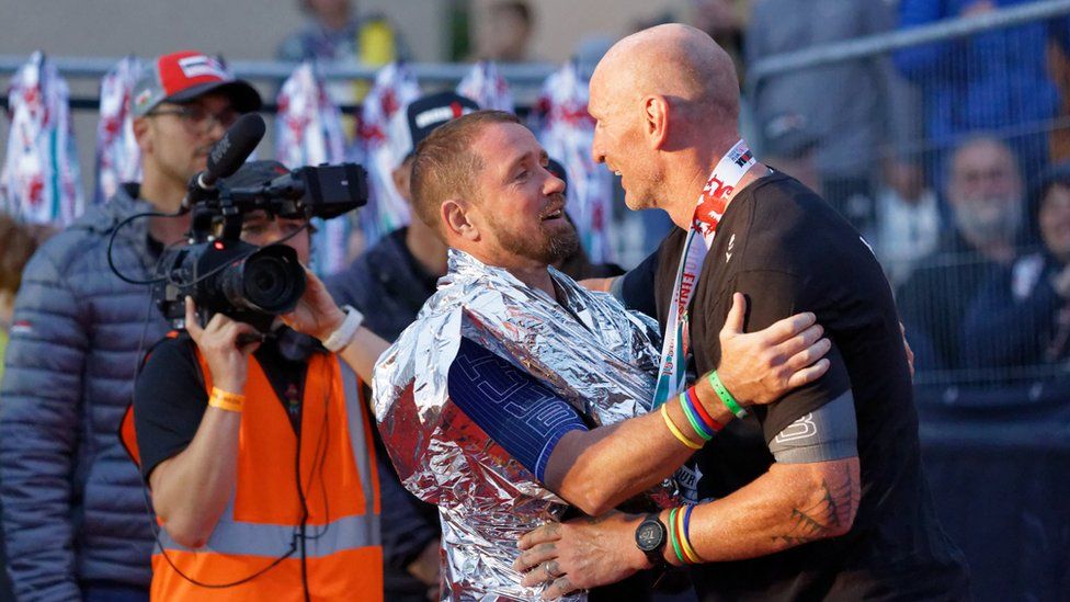 Shane Williams greets Gareth Thomas at the end of the Ironman triathlon