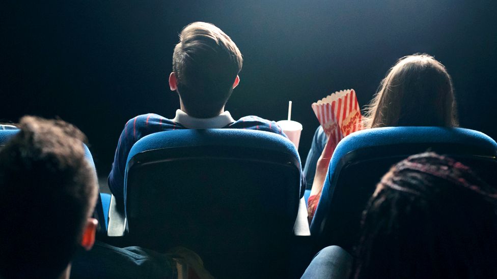 Audience members in a cinema watching a film