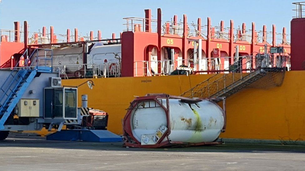 Damaged chemical storage container next to a vessel at Aqaba port in Jordan (27 June 2022)