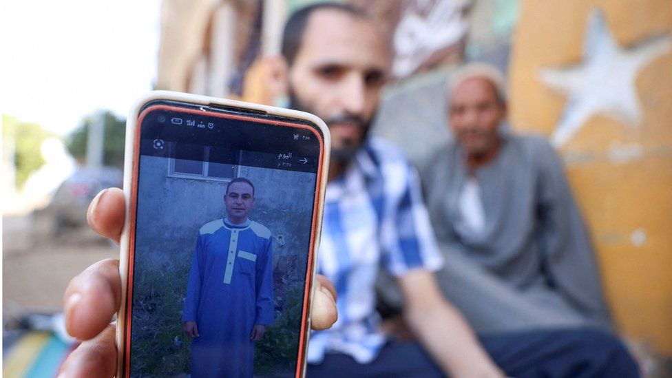 A man shows a photo of his brother Aly, who died along with his three cousins in Libya after Storm Daniel hit the countr