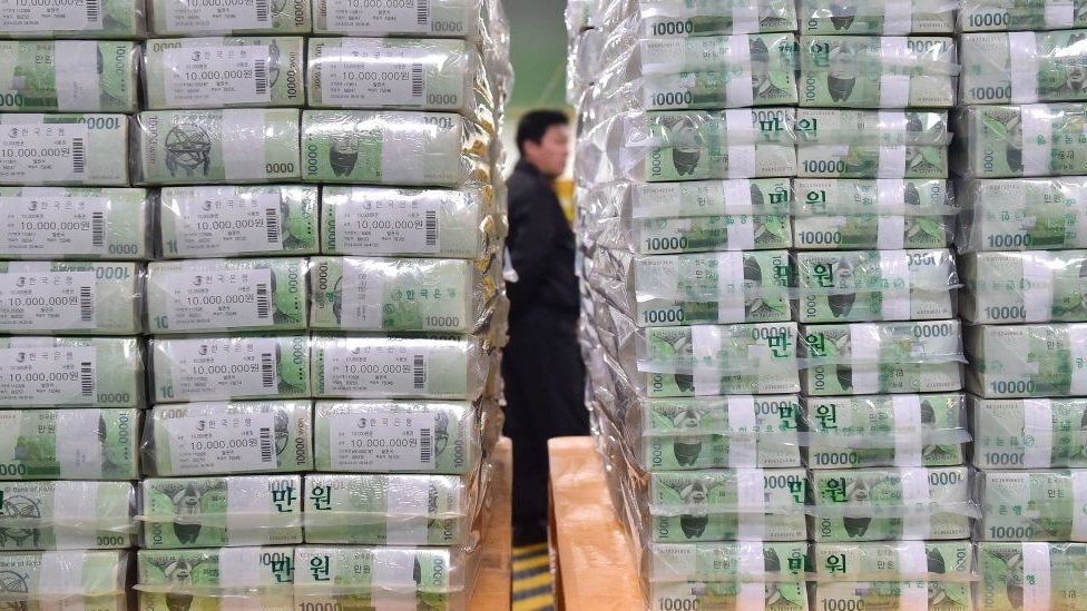Bundles of South Korean bank notes for release are stacked as a security worker is seen in the basement of the central bank in Seoul.