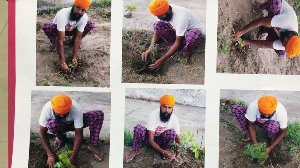 A man poses with plant saplings before applying for a gun license