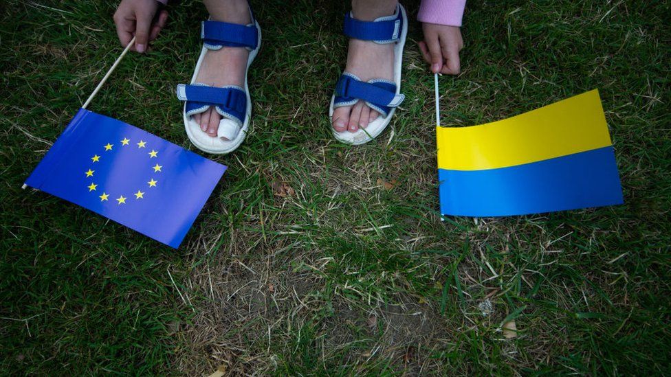 A Ukrainian girl holds the EU flag and Ukraine flag during the March supporting Ukraine for EU candidate membership in Dusseldorf on June 19, 2022