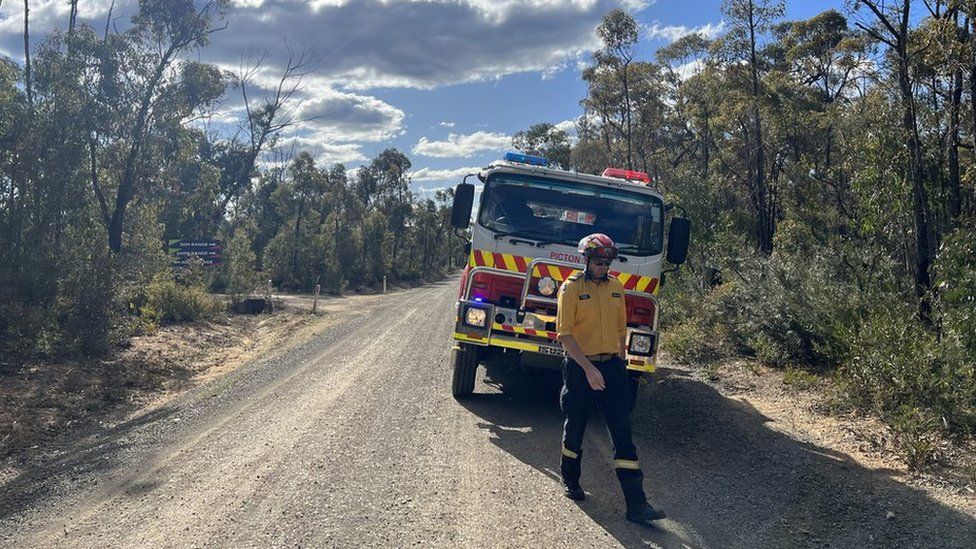 Andrew Hain walking in front of a fire truck