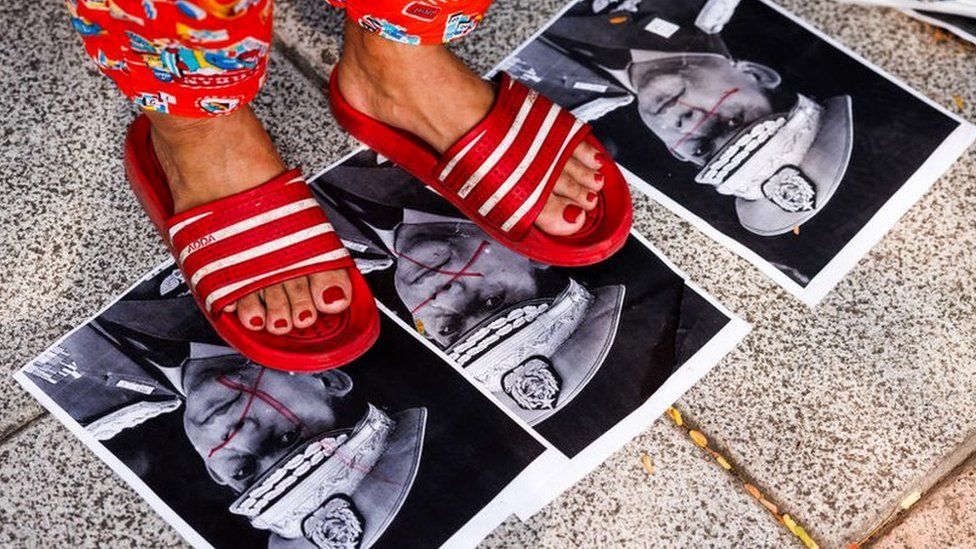 Myanmar people step on photos of military junta leader, General Min Aung Hlaing, during a gathering marking three years since the coup