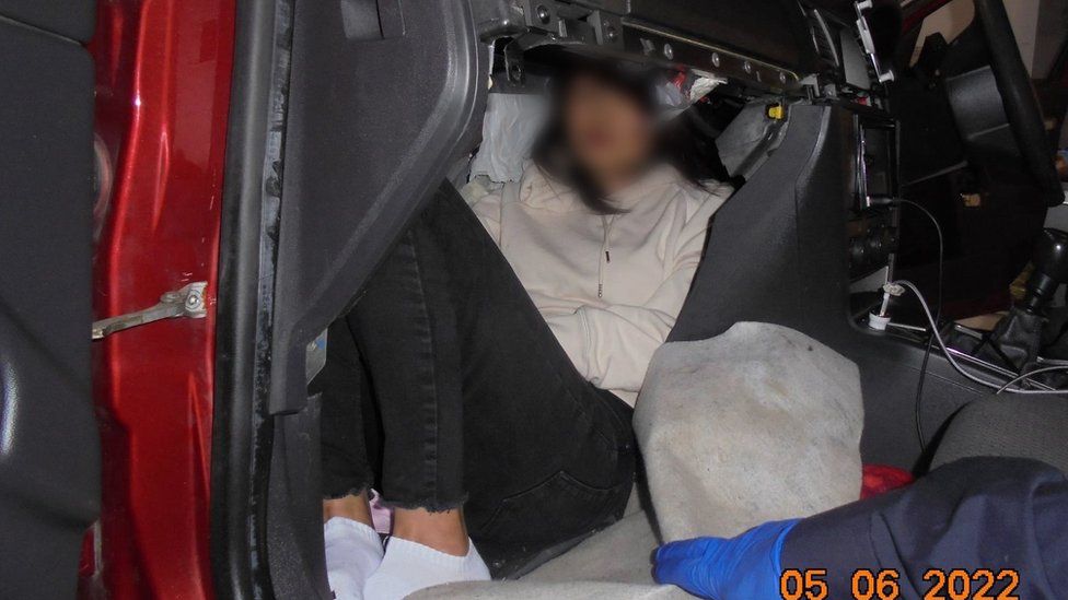 A picture of the woman cramped into the glovebox