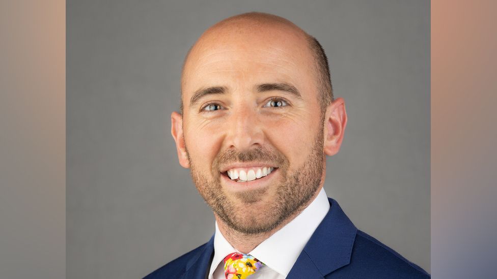 Matt Fisher of the Green Party wearing a navy blue suit and colourful floral tie