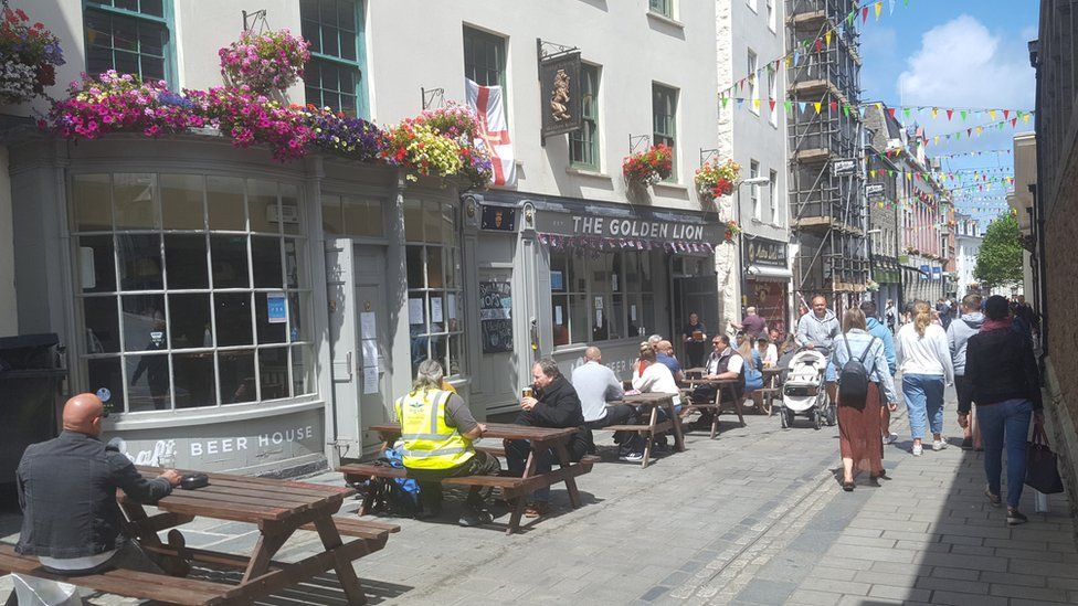 People sitting outside a pub having a drink.