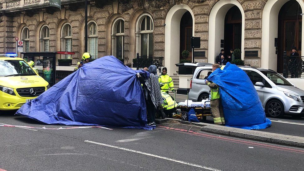 Photo of blue tarpaulin covering a member of the public while they were treated by paramedics