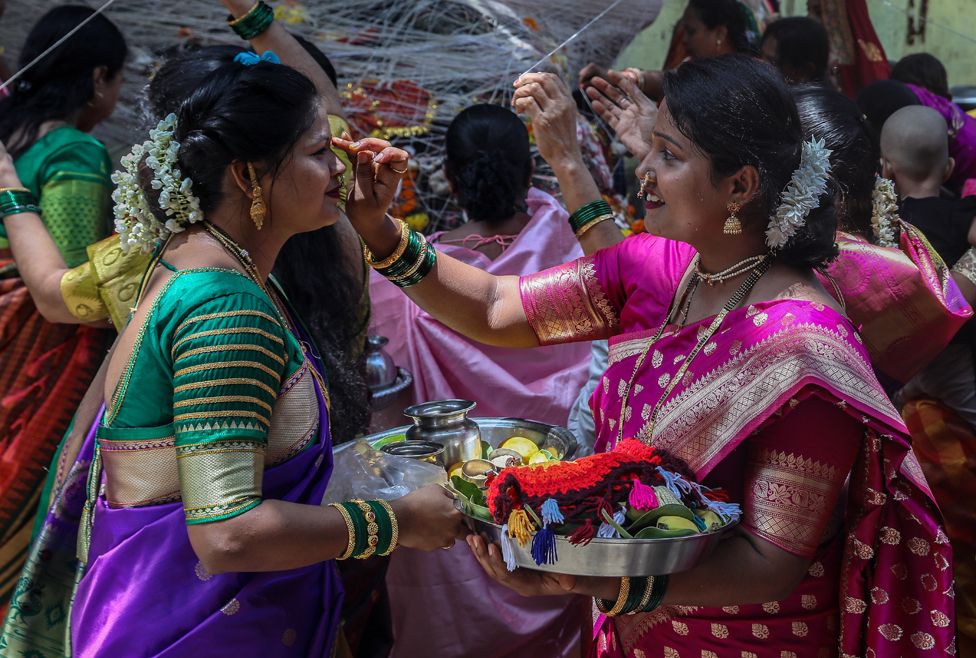 Hindu women perform rituals around a banyan tree during the Vat Savitri (also called Vat Purnima) festival in Bhayander, outskirts of Mumbai, India, 14 June 2022