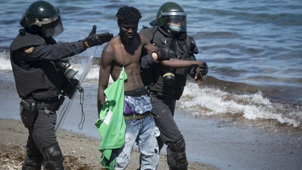 Spanish soldiers stand guard and intervene as migrants arrived swimming to Spanish territory of Ceuta on May 18, 2021