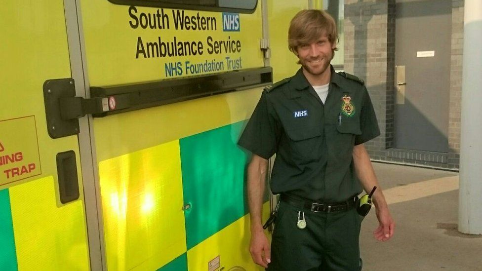Man stood in front of an ambulance in medical uniform