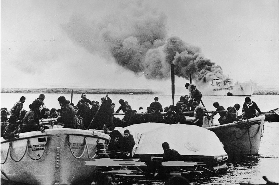 Lifeboats carrying crew and soldiers of 1st Battalion Welsh Guards reach shore at Fitzroy, having escaped from the blazing RFA SIR GALAHAD after the devastating Argentine air raid, 8 June 1982