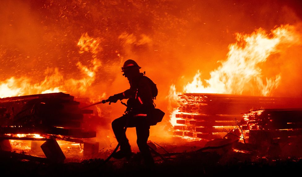 A firefighter douses flames as they push towards homes during the Creek fire in the Cascadel Woods area of unincorporated Madera County, California on 7 September 2020