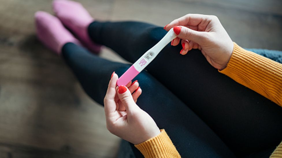 Anonymous woman with positive pregnancy test at home