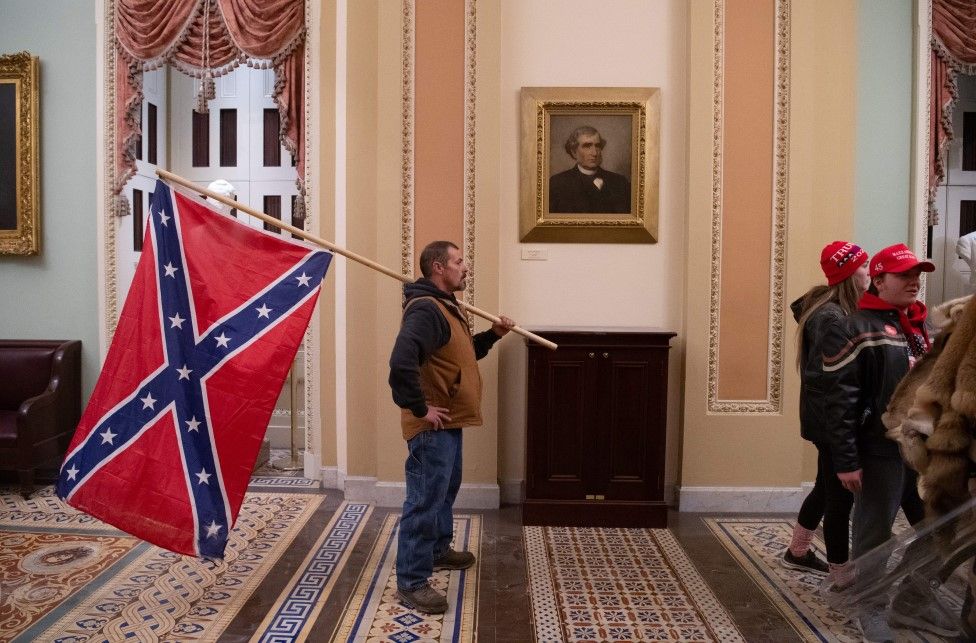 A Trump supporter holds a Confederate flag outside the Senate Chamber