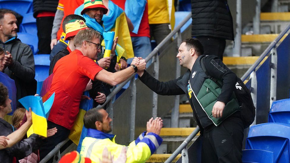 Welsh fan shakes hand with a Ukraine fan
