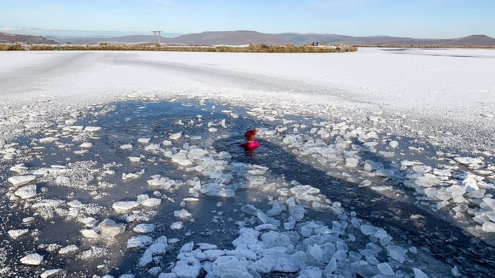 woman swimming in frozen pond