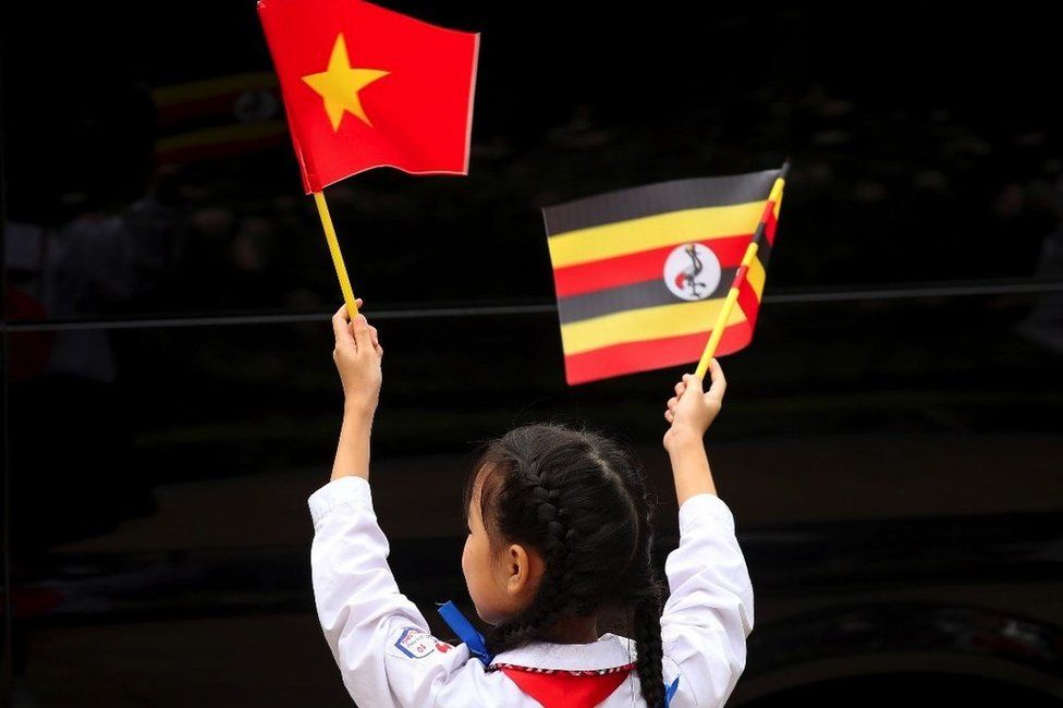 A little girl waves flags of Vietnam and Uganda during a welcome ceremony at the Presidential Palace in Hanoi, Vietnam, 24 November 2022