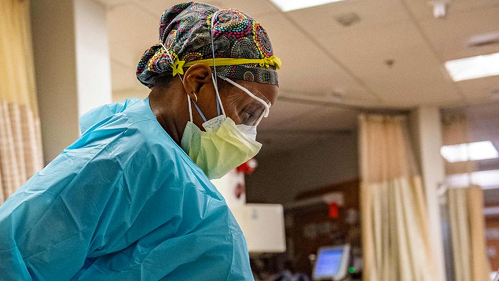 A medical workers puts on PPE before entering a negative pressure room at a US hospital