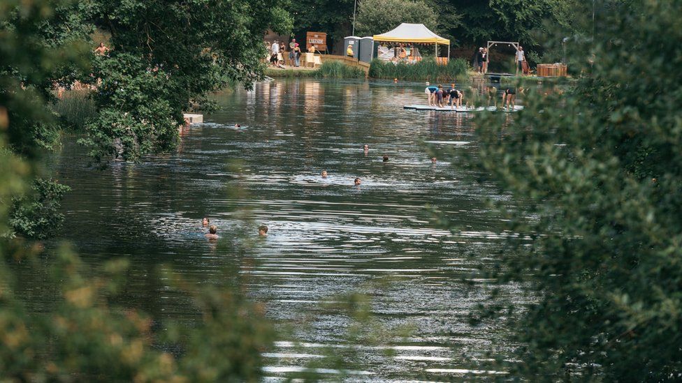 People swimming in a lake at Cornbury Lake