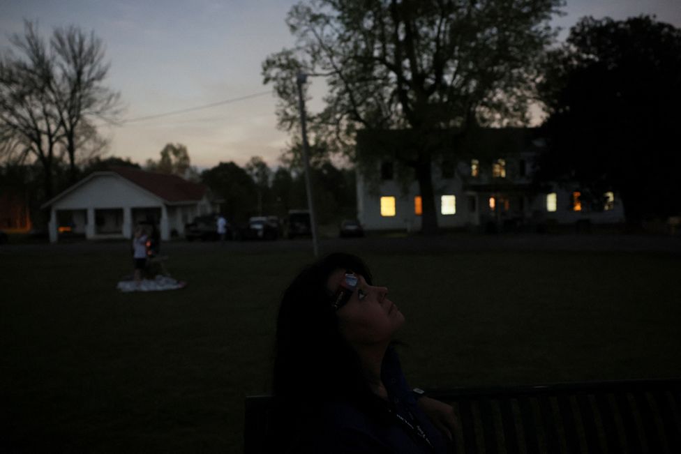 Debbie Ward looks to the sky during the total solar eclipse, where the moon blots out the sun, at Wheelock Academy, in Millerton, OK, U.S. April 8, 2024.