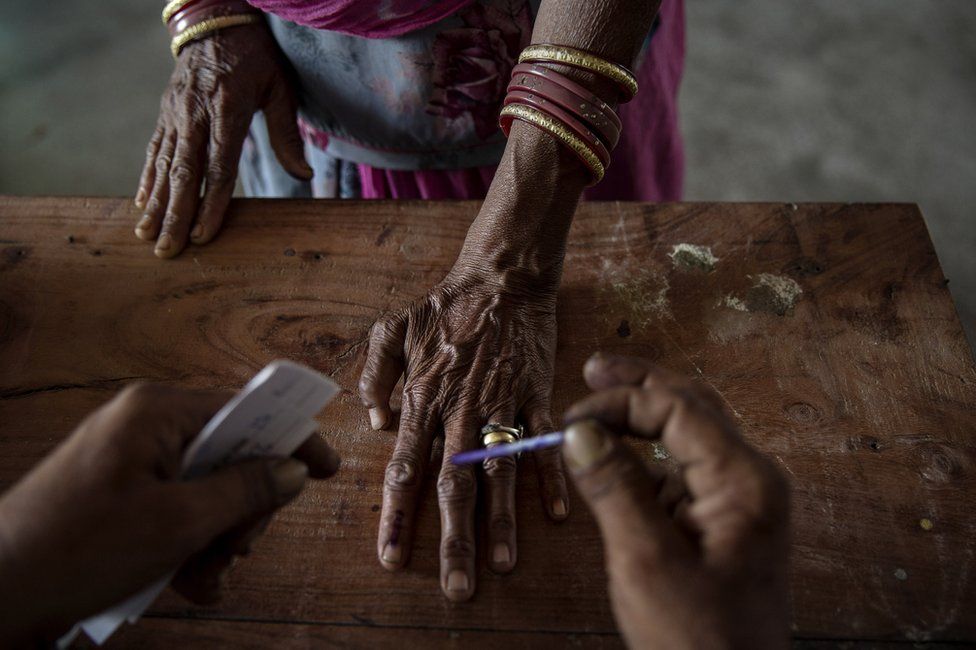 An Indian woman has her finger inked by an election worker before voting in 2014.