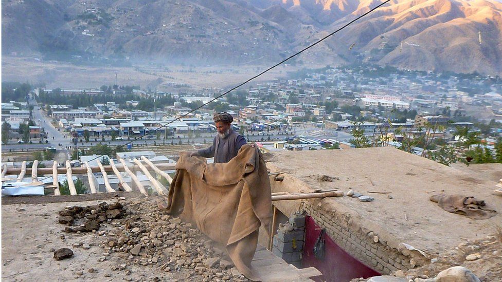 An Afghan repairs his roof damaged in an earthquake, in Badakhshan, Afghanistan (26 October 2015)