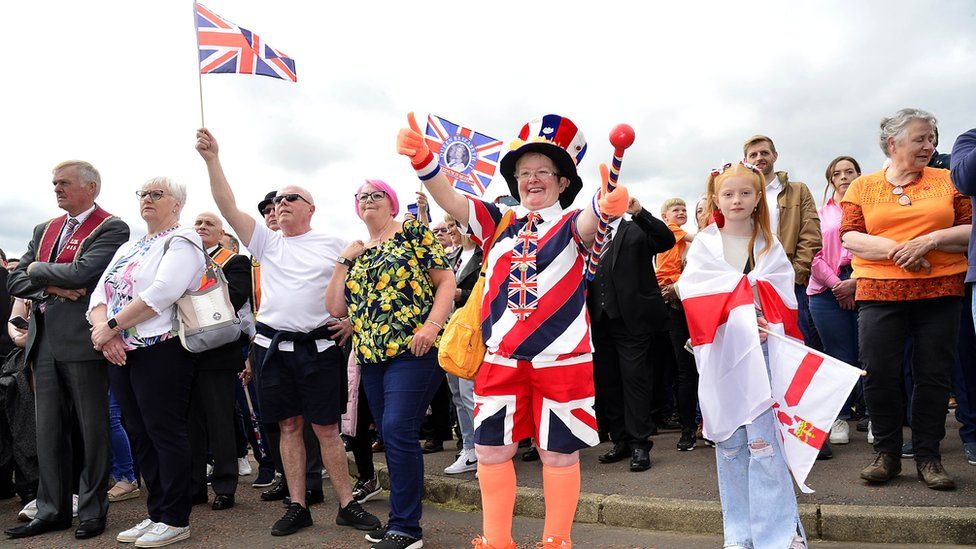 Spectators of the parade waving Union Jack flags and dressed up
