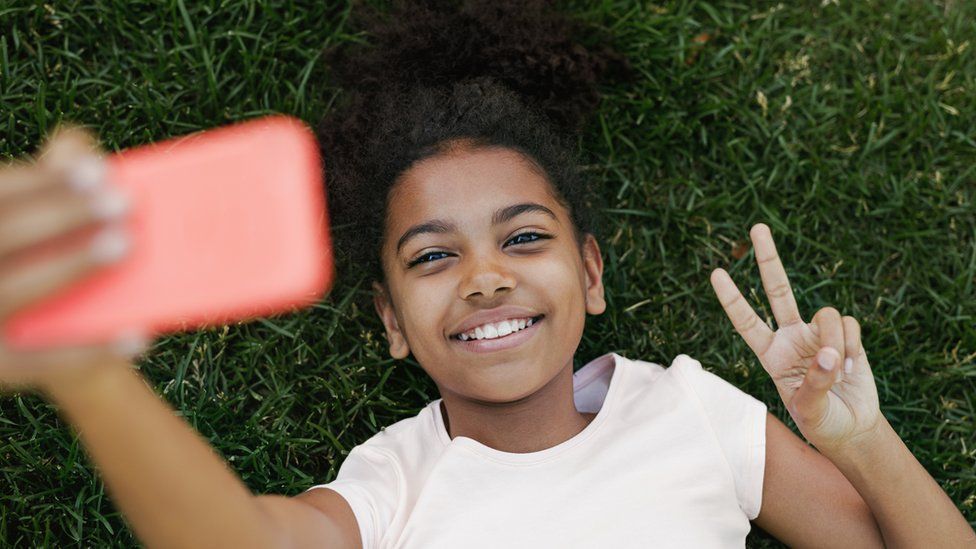 young girl takes selfie on smart phone