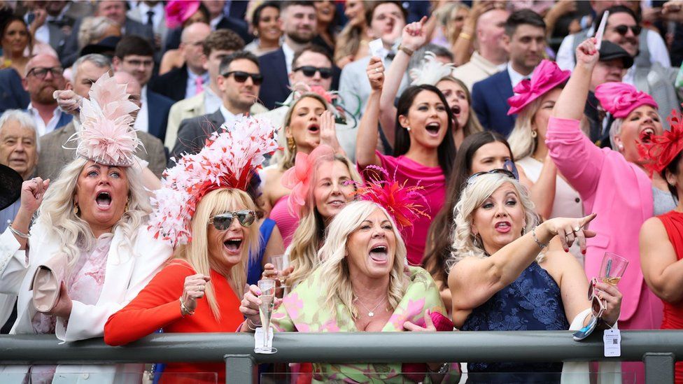 Crowds cheering on horse race at Aintree Ladies day 2024