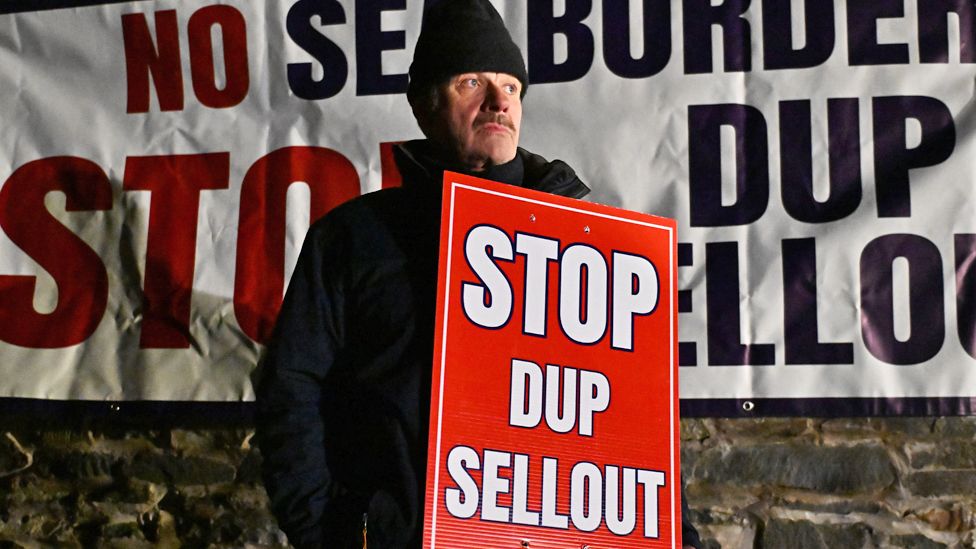Unionist protestors demonstrate against a possible DUP decision to accept the government offer to go back into the Stormont assembly outside Larchfield House on 29 January 2024 in Lisburn, Northern Ireland