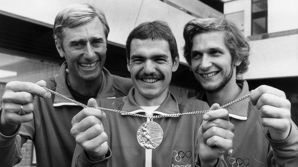 Jim Fox, left, Danny Nightingale and Adrian Parker holding a gold medal on a chain