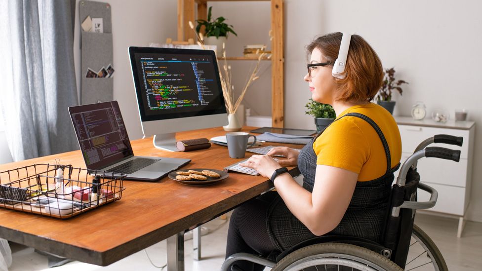 Woman in a wheelchair working from home