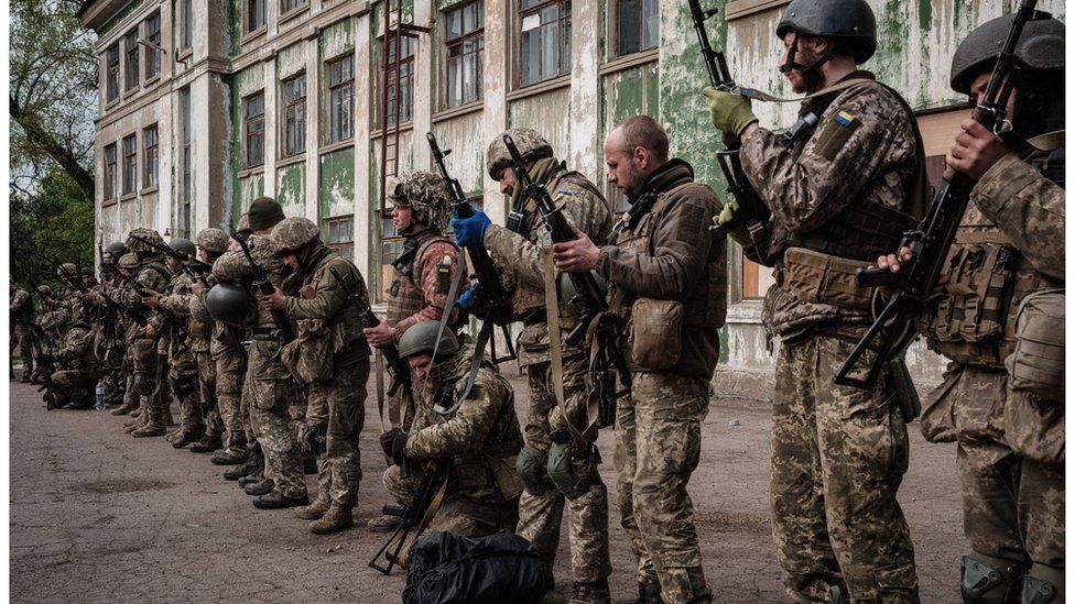 Ukrainian soldiers unload their guns as they arrive at an abandoned building to rest and receive medical treatment after fighting on the front line for two months near Kramatorsk, eastern Ukraine on April 30, 2022.