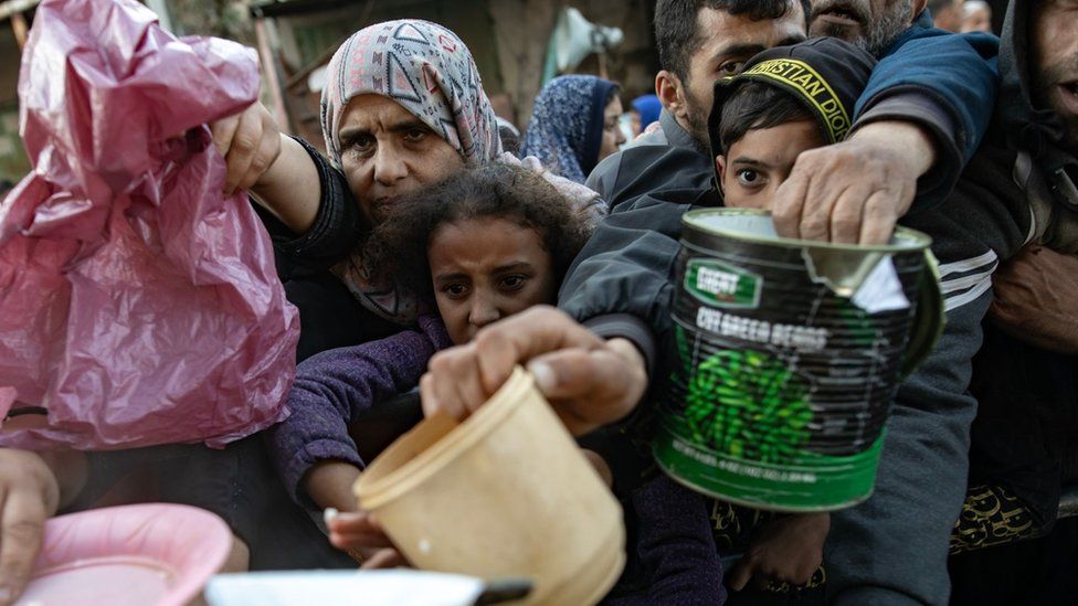 Displaced Palestinians gather to collect food in Rafah, in the southern Gaza Strip (14 March 2024)