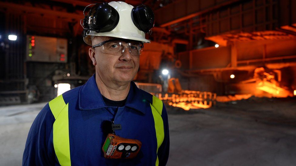 Henrik Adam with steelmaking works behind him